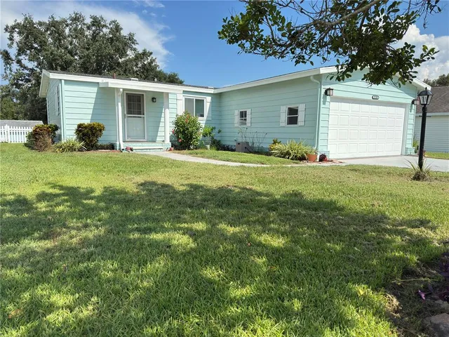 a view of a house with a yard and a garage