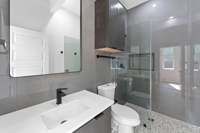 a bathroom with a sink toilet and shower