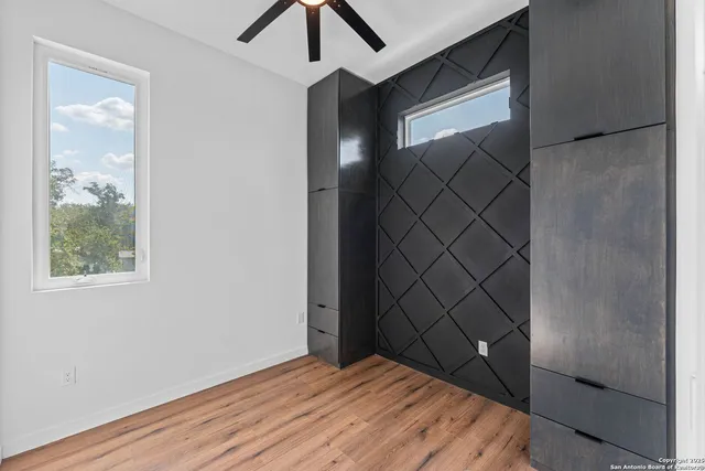 an empty room with wooden floor and windows