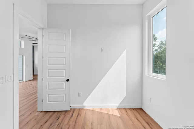 an empty room with wooden floor and windows