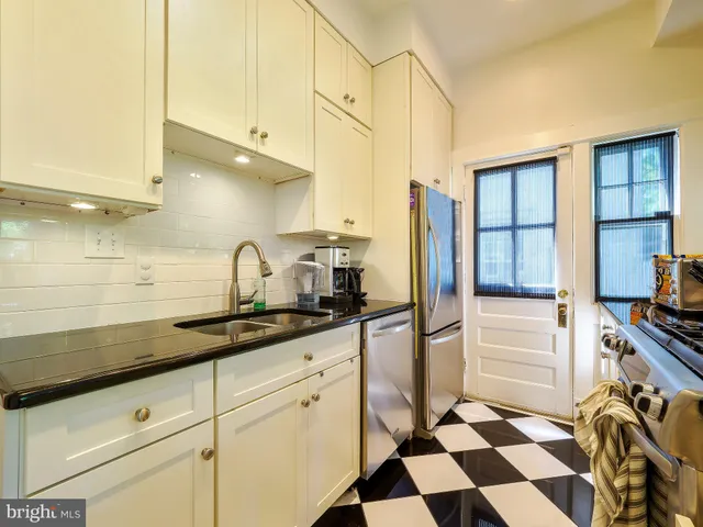 a kitchen with a sink a refrigerator and cabinets