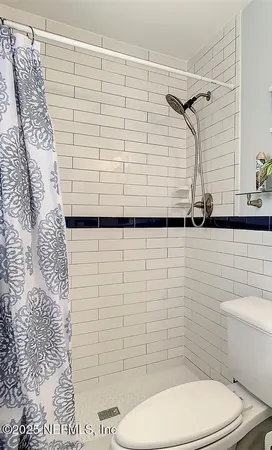 a bathroom with a toilet and a shower