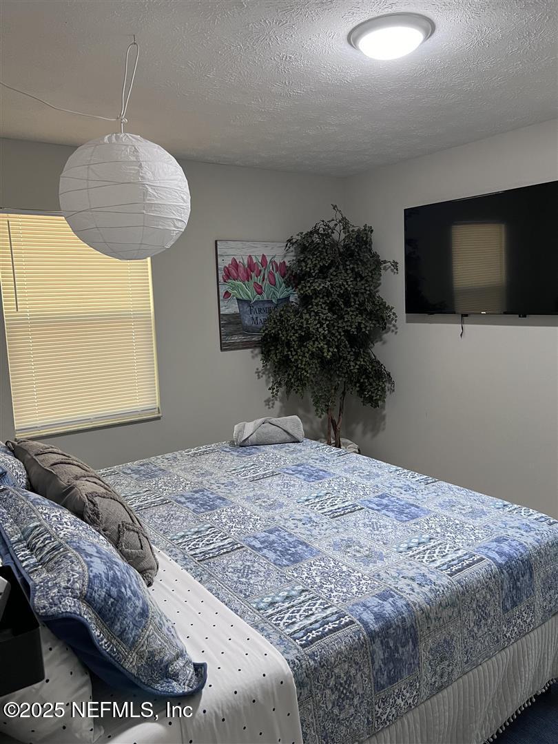 460 Lobelia Road St. Augustine, FL 32086 - Photo 22 of 34 a bedroom with a bed and a flat screen tv