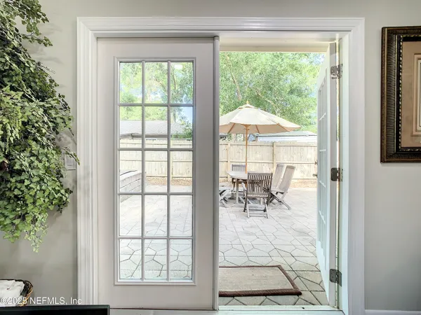 a dining room with wooden floor and a floor to ceiling window