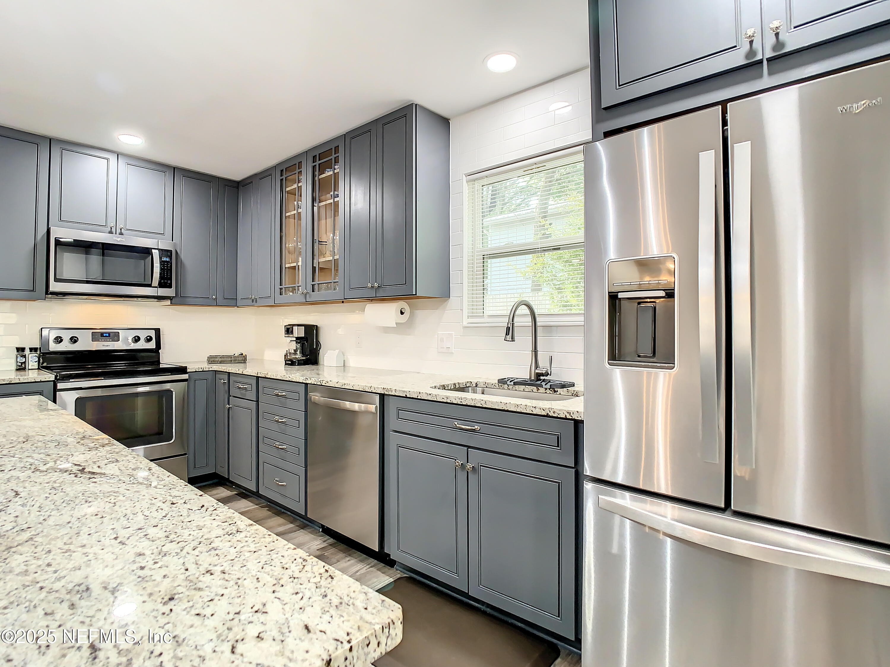 460 Lobelia Road St. Augustine, FL 32086 - Photo 10 of 34 a kitchen with stainless steel appliances granite countertop a refrigerator a stove a sink and a microwave
