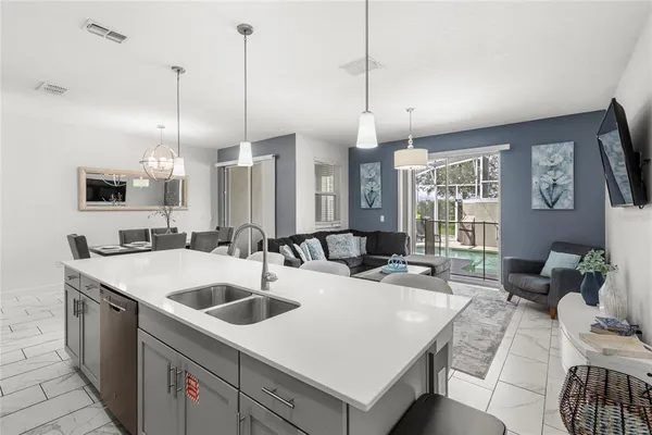 a kitchen with a sink a counter top space and living room view