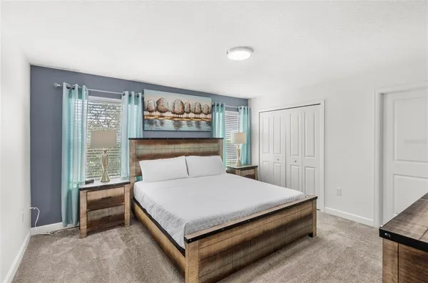 a large bed sitting in a bedroom next to a window