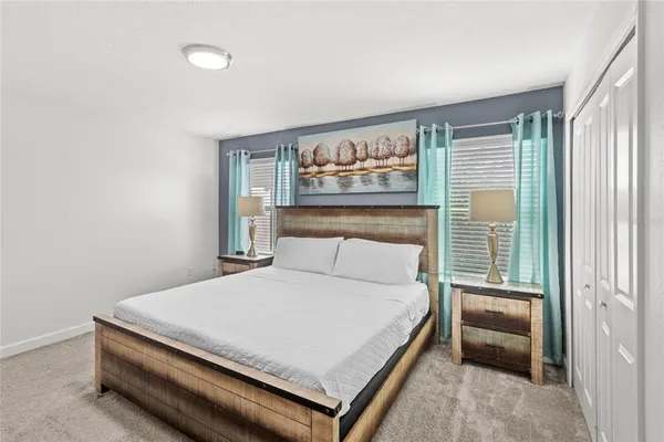 a bedroom with a bed and a painting on the wall