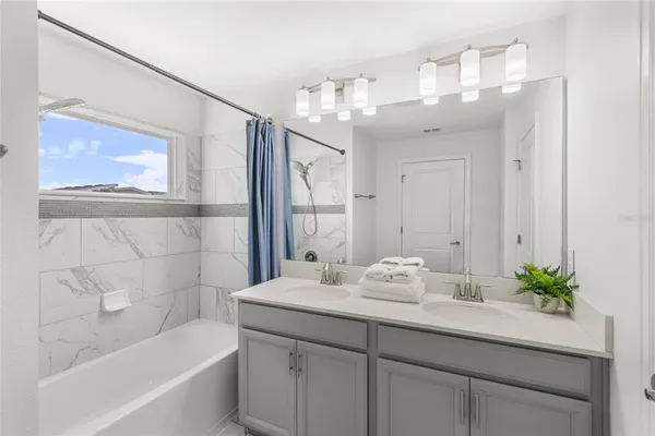 a bathroom with a sink a large mirror and a bathtub
