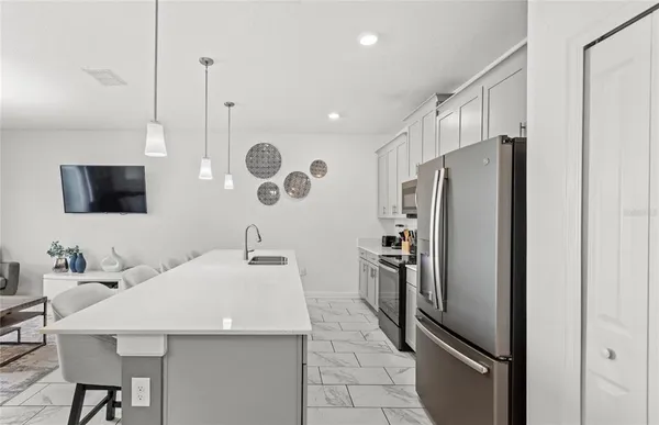 a kitchen with stainless steel appliances a refrigerator sink and microwave