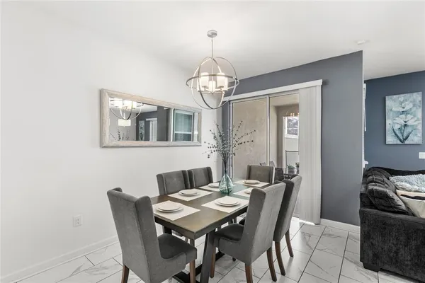 a view of a dining room with furniture a chandelier and wooden floor
