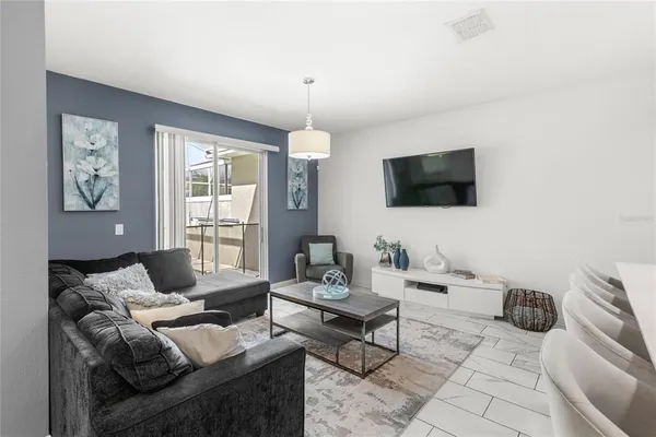 a living room with furniture a flat screen tv and a large window