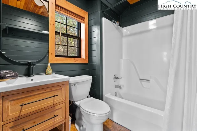 a bathroom with a granite countertop toilet sink and mirror