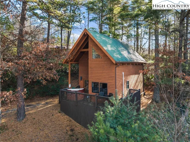 a backyard of a house with wooden fence and large trees