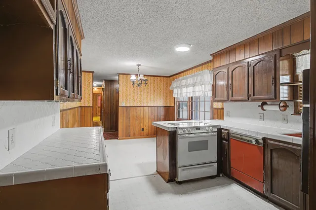 a kitchen with stainless steel appliances kitchen island granite countertop a refrigerator and a stove top oven
