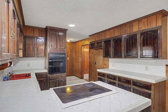 a kitchen with granite countertop a sink stove and cabinets