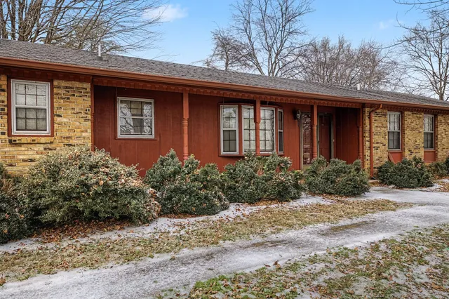 a view of a hallway with wooden floor and a dining table