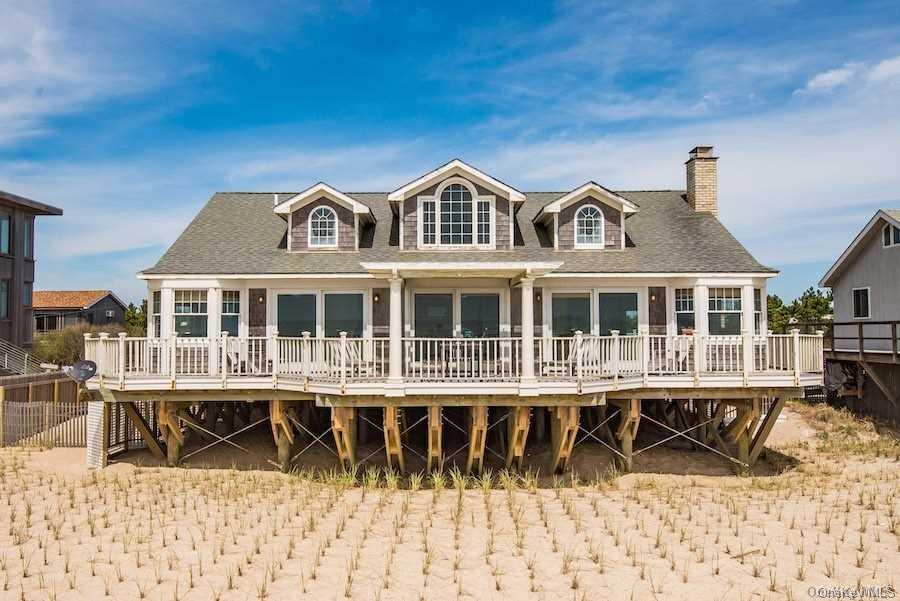 77 E Walk Ocean Beach, NY 11770 - Photo 1 of 1 a front view of a building with a garden