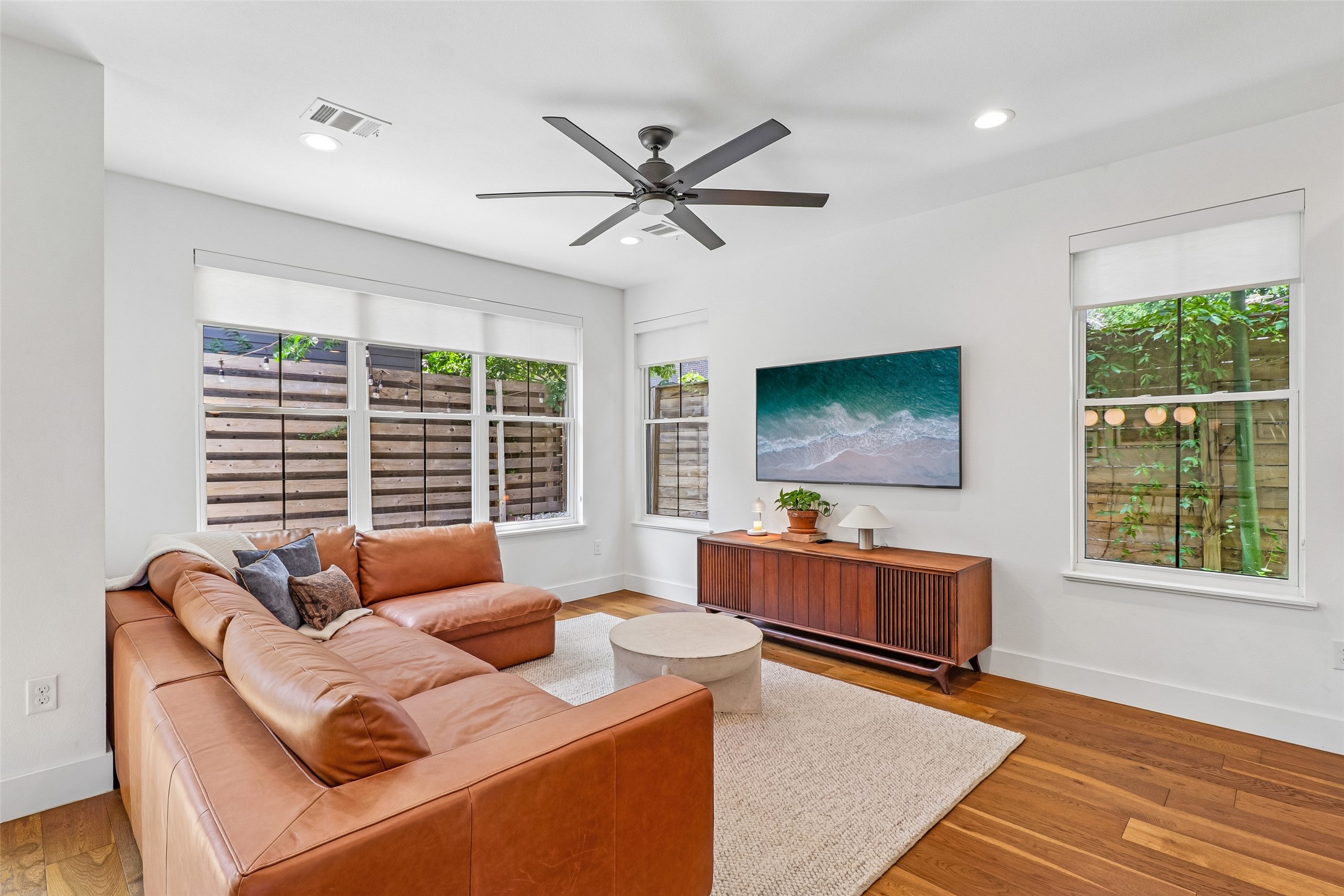 1706 Perez Street, Unit 1 Austin, TX 78721 - Photo 5 of 36 Hardwood flooring and numerous windows define this bright living area, creating an inviting atmosphere.
