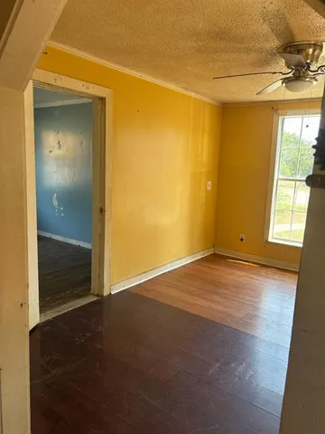 an empty room with wooden floor and a bathroom
