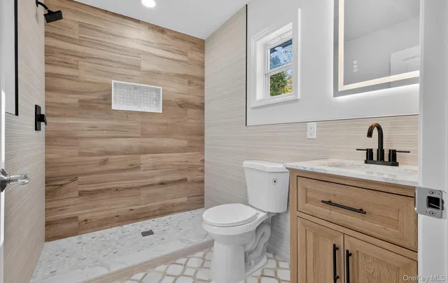 a bathroom with a toilet a sink and mirror