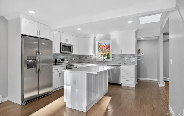 a kitchen with stainless steel appliances a sink stove refrigerator and cabinets