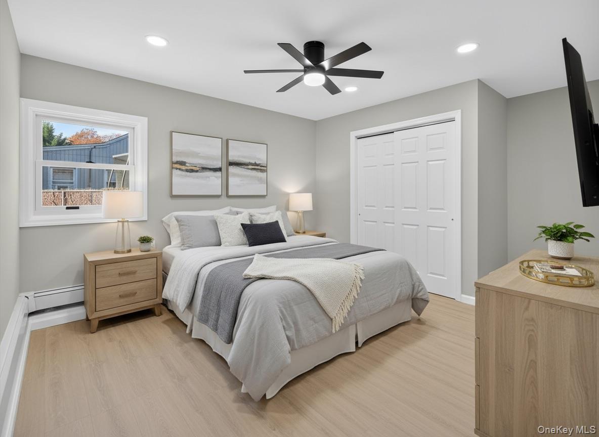 14 Muncey Road Bay Shore, NY 11706 - Photo 10 of 13 Bedroom featuring light wood finished floors, recessed lighting, ceiling fan, a closet, and a baseboard heating unit (virtually staged)