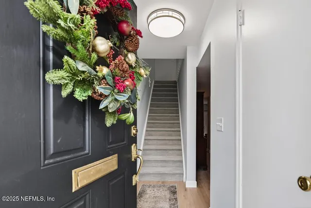 a white toilet sitting next to a shower and a wooden floor