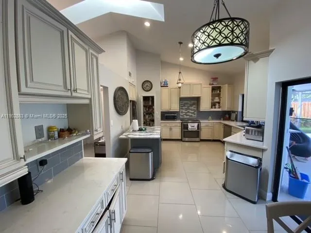 a kitchen with a stove cabinets and window