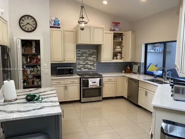 a kitchen with cabinets and chairs