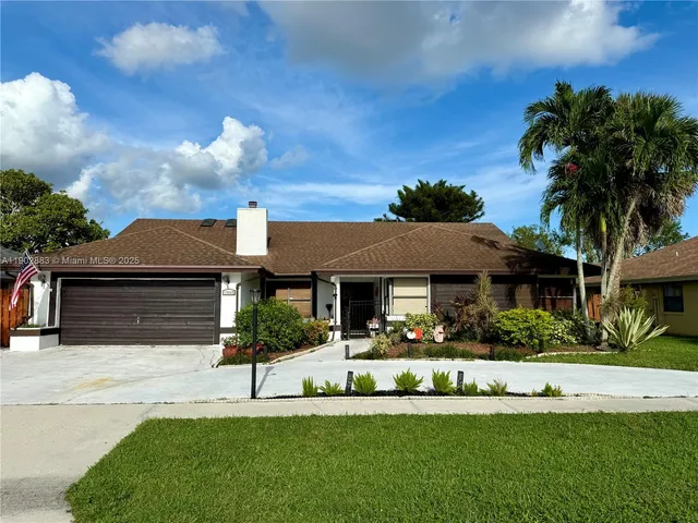 a front view of a house with a garden and plants