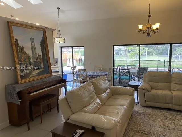 a living room with furniture and a chandelier