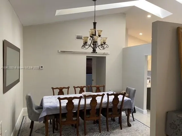 a view of a dining room with furniture and chandelier
