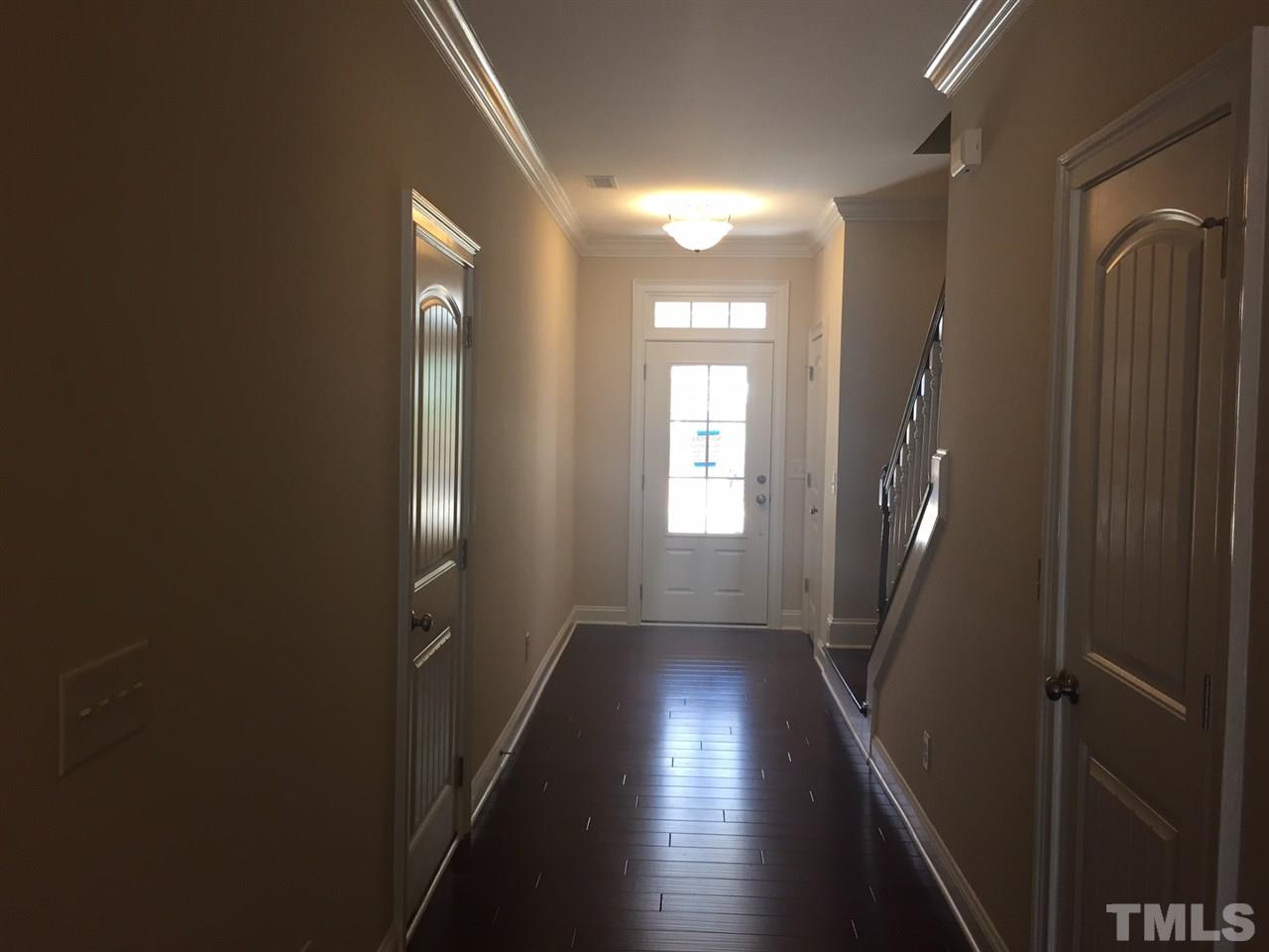 741 Fallon Grove Way Raleigh, NC 27608 - Photo 3 of 16 a view of a hallway with wooden floor and staircase