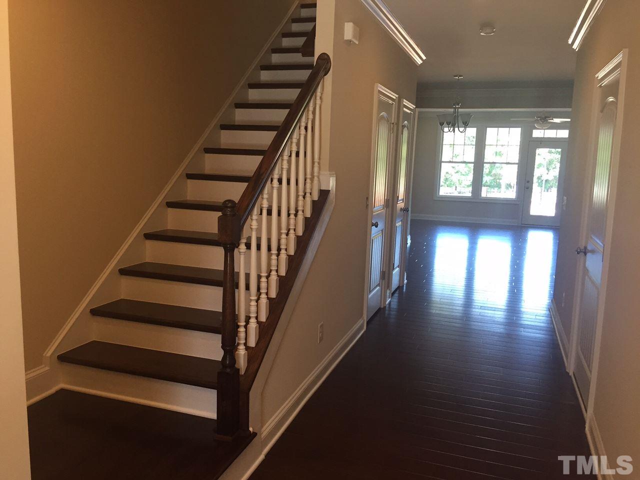 741 Fallon Grove Way Raleigh, NC 27608 - Photo 4 of 16 wooden view of staircase with lots of frames on wall and wooden floor