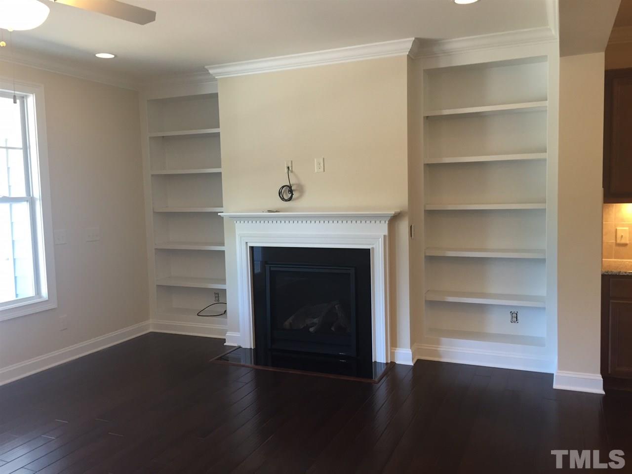 741 Fallon Grove Way Raleigh, NC 27608 - Photo 8 of 16 a living room with a fireplace and wooden floor