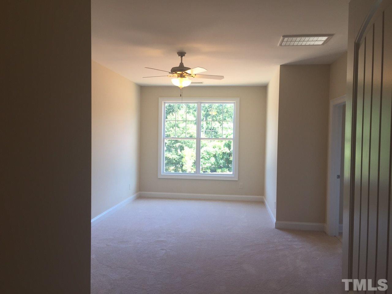 741 Fallon Grove Way Raleigh, NC 27608 - Photo 10 of 16 an empty room with windows and chandelier fan