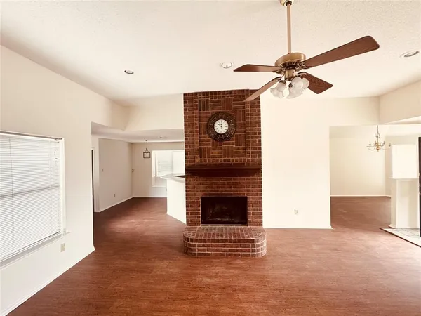 a view of an empty room with a fireplace and a window