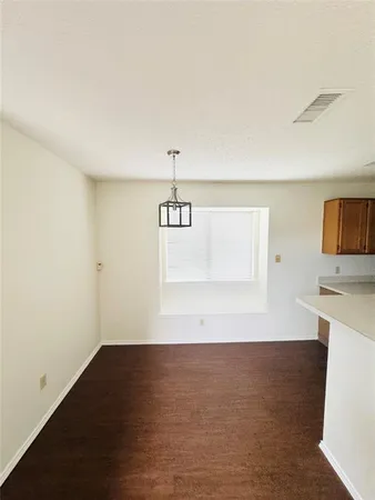 a view of a room with wooden floor and white walls