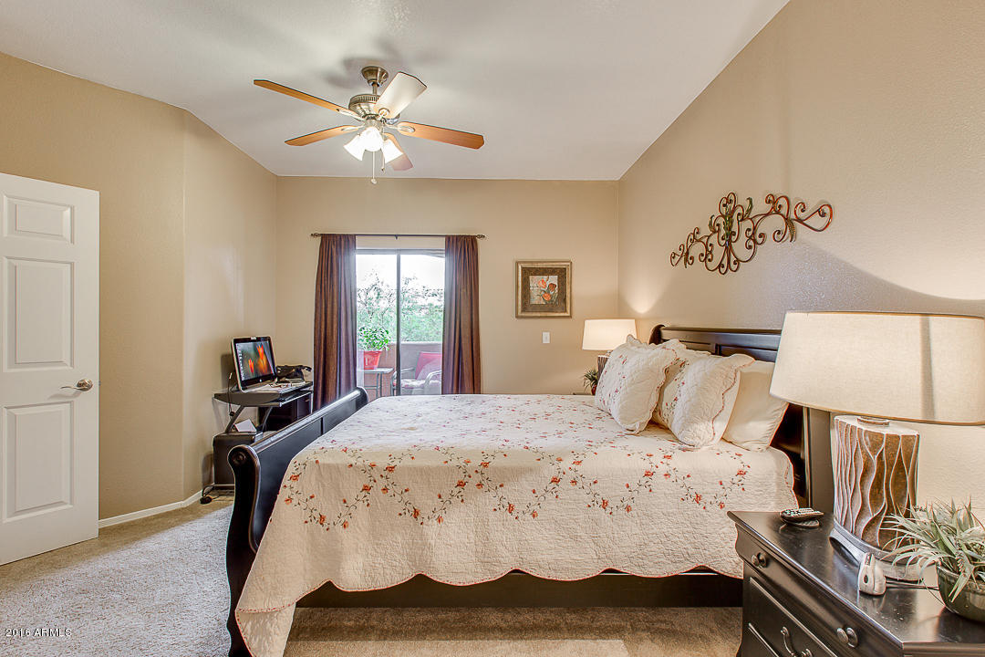 10030 West Indian School Road, Unit 269 Phoenix, AZ 85037 - Photo 19 of 34 a bedroom with a bed and a chandelier