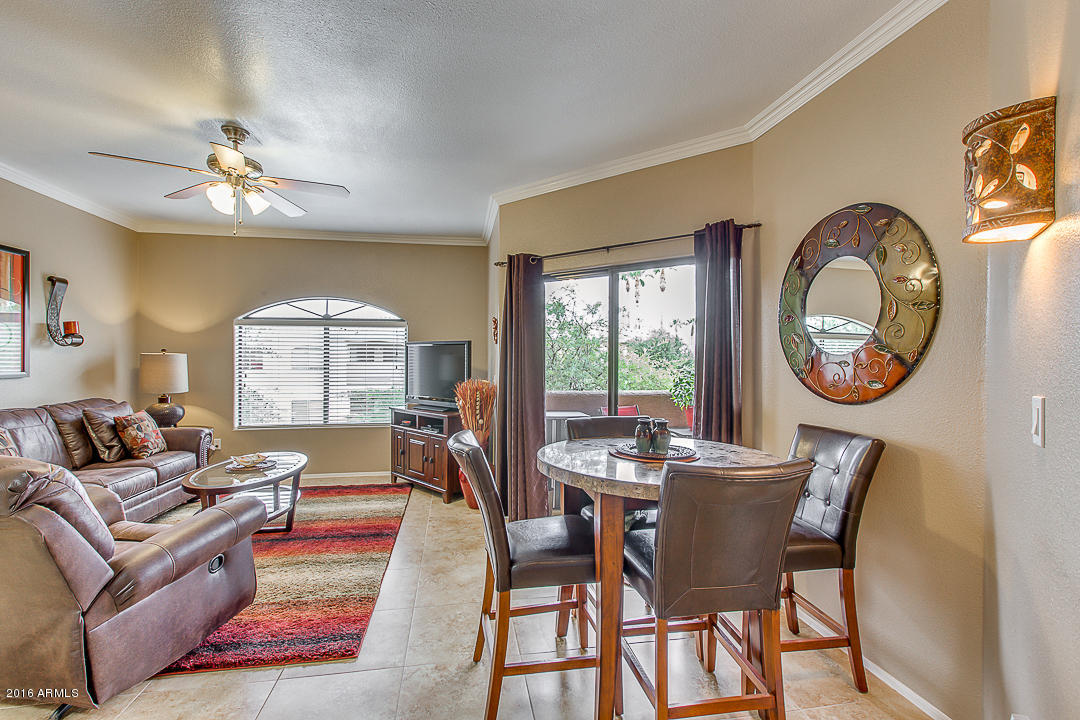 10030 West Indian School Road, Unit 269 Phoenix, AZ 85037 - Photo 6 of 34 a dining room with furniture a large window and a mirror