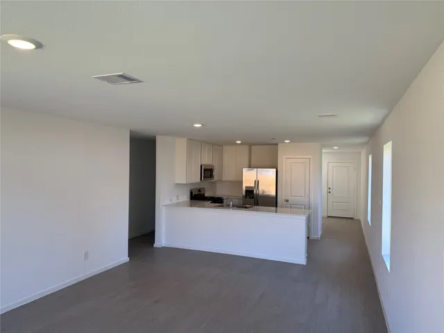 a view of a kitchen with a sink and a refrigerator
