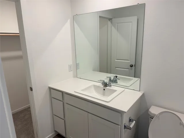 a bathroom with a sink toilet and mirror