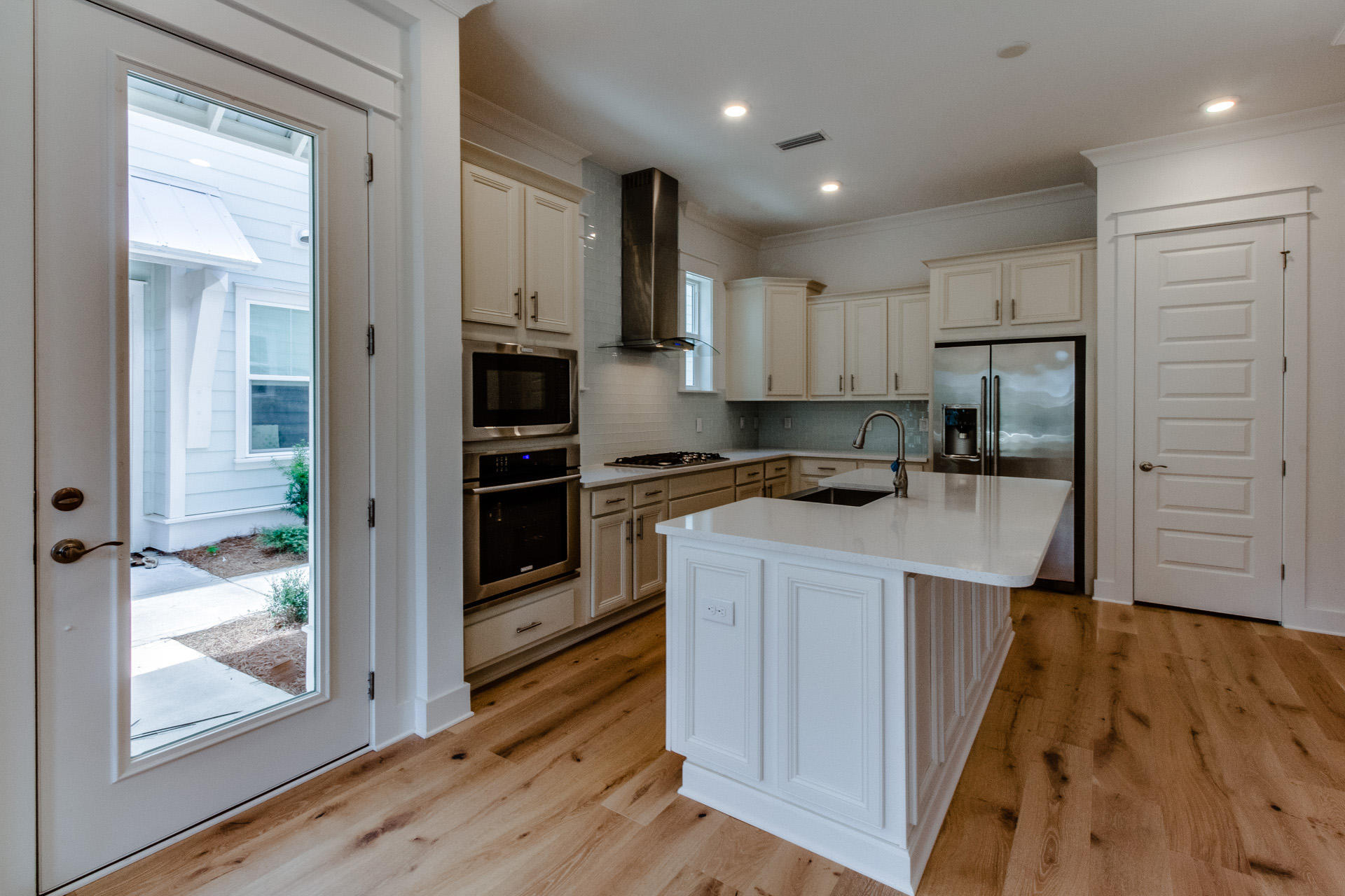 138 Pine Lands Loop Inlet Beach, Unit B Inlet Beach, FL 32461 - Photo 4 of 32 a kitchen with kitchen island wooden floors appliances and cabinets