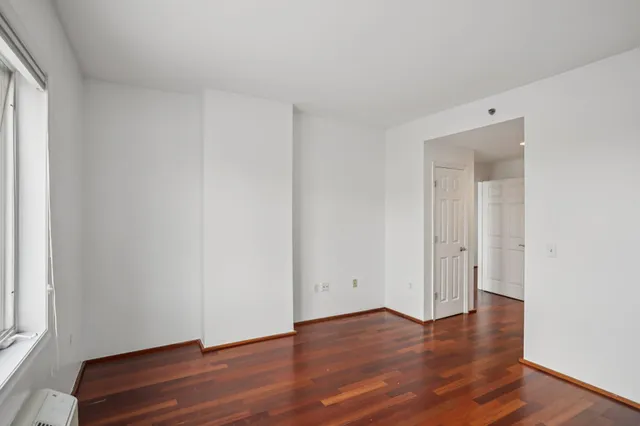a view of an empty room with wooden floor