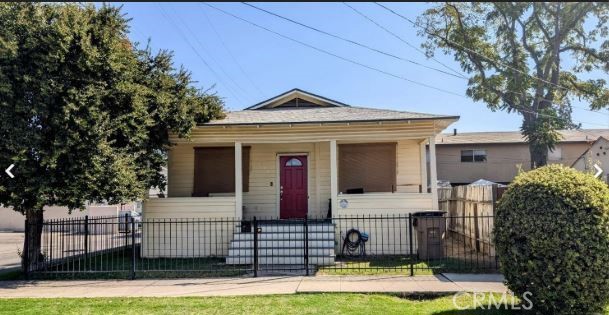 a view of a white house with large windows and a small yard