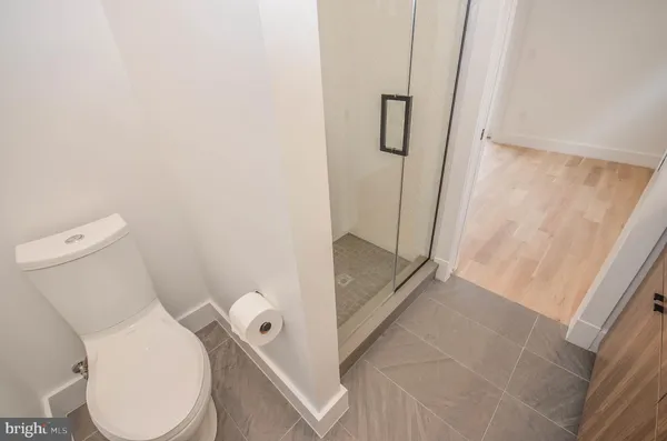 a white toilet sitting next to a shower