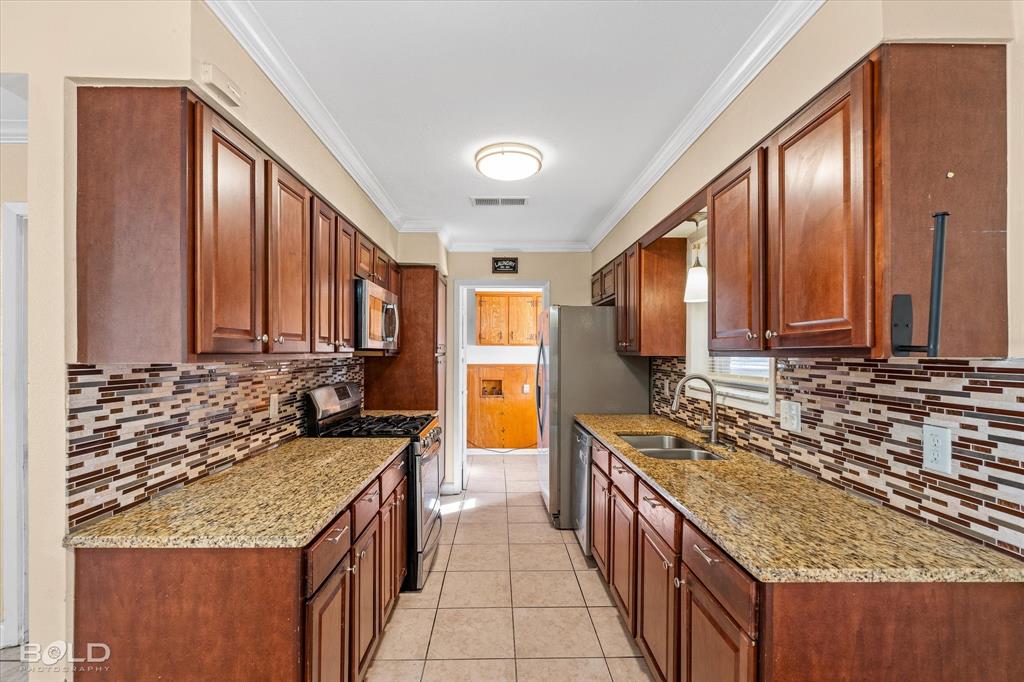 2710 Higgins Drive Shreveport, LA 71104 - Photo 19 of 37 a kitchen with stainless steel appliances granite countertop a stove a sink and a refrigerator