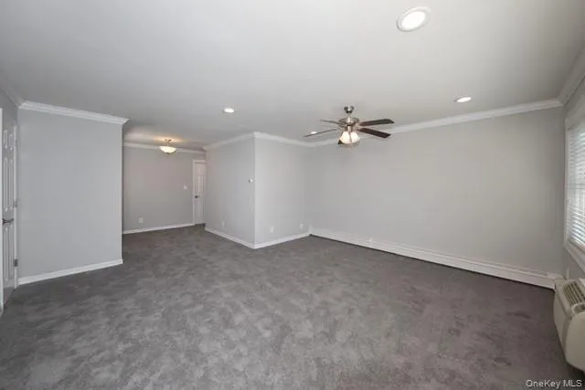 an empty room with a fan & a ceiling fan