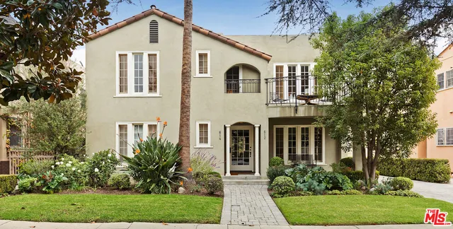 a view of a white house with a yard and plants